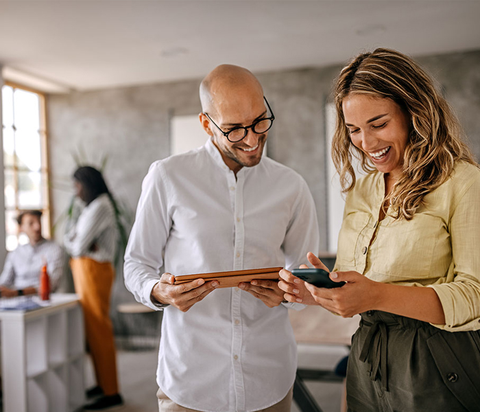 Two people using a tablet and phone