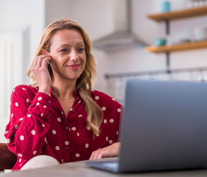 Woman using her phone and laptop
